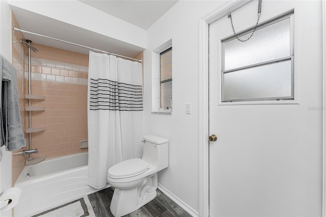 bathroom with hardwood / wood-style floors, a textured ceiling, shower / tub combo, and toilet