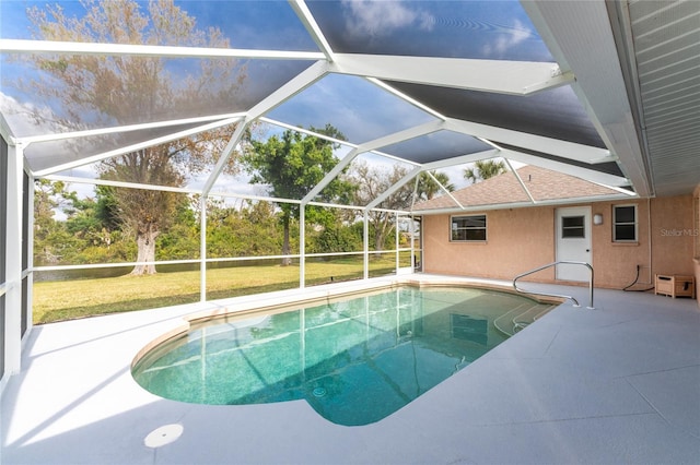 view of swimming pool with a yard, a patio, and a lanai