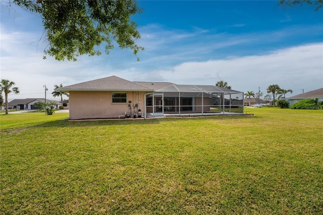 rear view of property with a lawn and a lanai