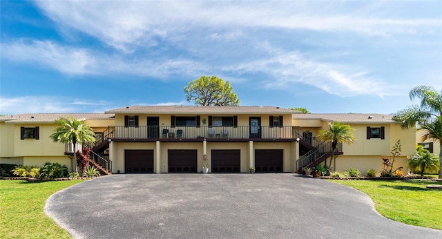 view of property with a garage and a front lawn