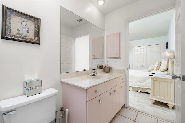 bathroom featuring tile patterned flooring, vanity, and toilet