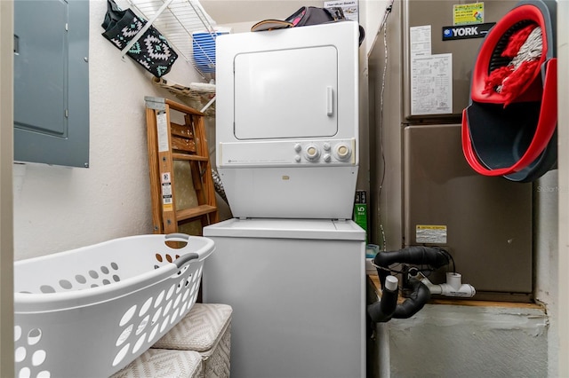 laundry room featuring stacked washing maching and dryer and electric panel