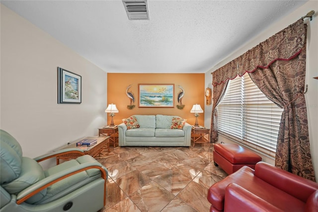 living room featuring light tile flooring and a textured ceiling