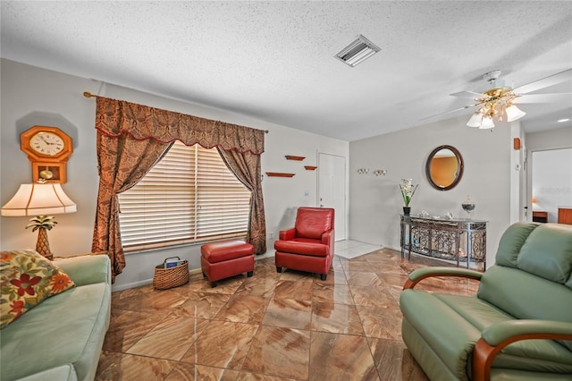 tiled living room with a textured ceiling and ceiling fan