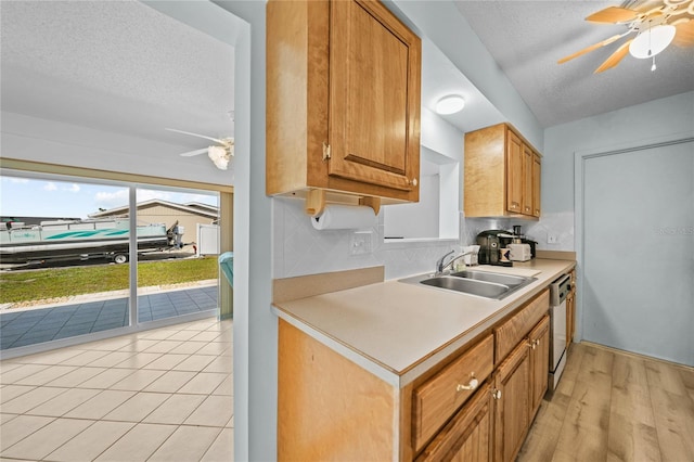 kitchen with backsplash, sink, ceiling fan, and light hardwood / wood-style flooring