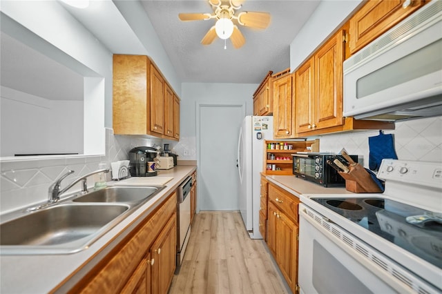 kitchen featuring ceiling fan, tasteful backsplash, light hardwood / wood-style flooring, white appliances, and sink