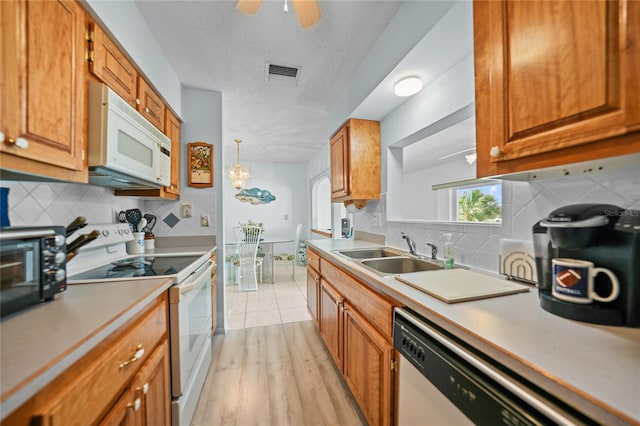 kitchen with white appliances, ceiling fan, sink, tasteful backsplash, and a textured ceiling