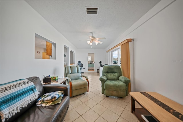 tiled living room featuring ceiling fan and a textured ceiling