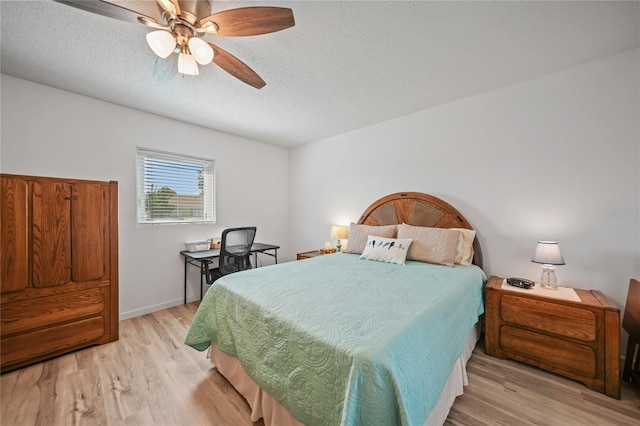 bedroom with a textured ceiling, ceiling fan, and light hardwood / wood-style flooring