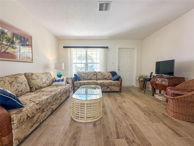 living room featuring a textured ceiling and light hardwood / wood-style floors