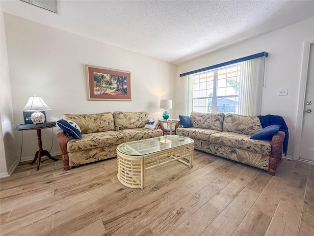 living room with light hardwood / wood-style floors and a textured ceiling