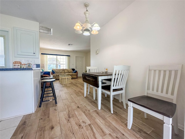 dining area with a chandelier and light hardwood / wood-style floors