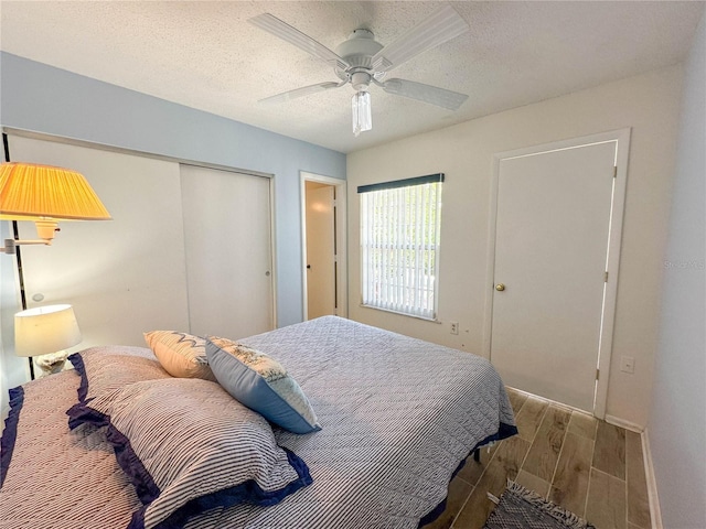 bedroom featuring ceiling fan, dark hardwood / wood-style floors, a textured ceiling, and a closet