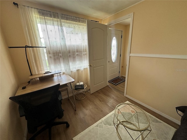 office with a healthy amount of sunlight, ornamental molding, and hardwood / wood-style floors