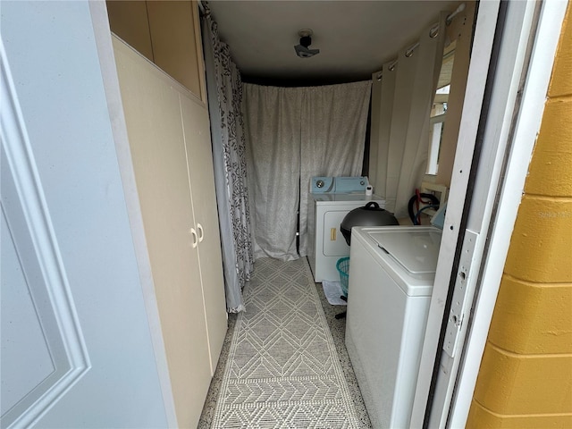 laundry room with light tile patterned flooring and washer and clothes dryer