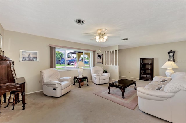 carpeted living room featuring ceiling fan and a textured ceiling