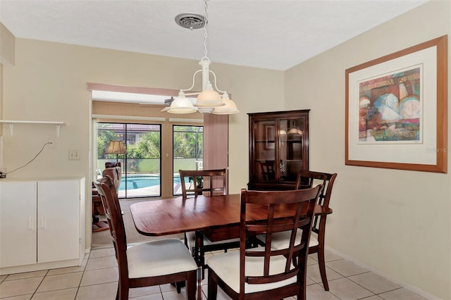 dining area featuring an inviting chandelier and light tile floors