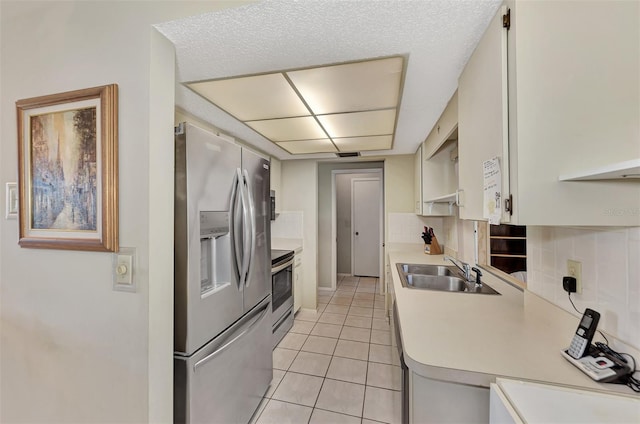 kitchen with light tile floors, tasteful backsplash, sink, and stainless steel appliances