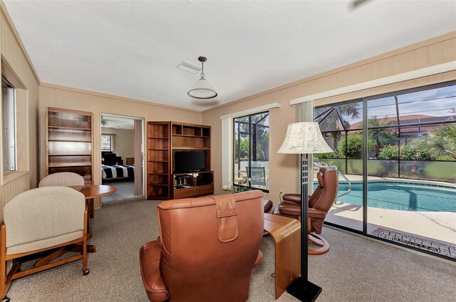 living room featuring light carpet, crown molding, and ceiling fan