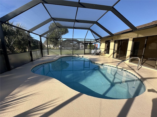 view of swimming pool with glass enclosure and a patio