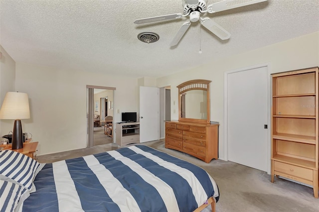 carpeted bedroom with ceiling fan and a textured ceiling