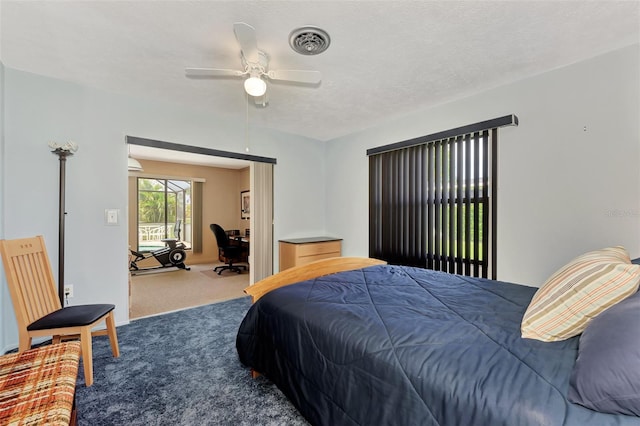 bedroom with ceiling fan, carpet floors, and a textured ceiling