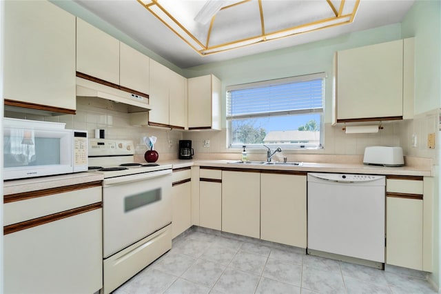 kitchen featuring decorative backsplash, sink, light tile patterned flooring, and white appliances