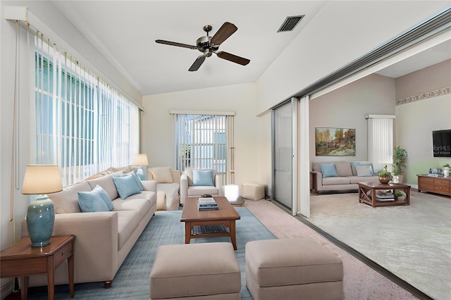 living room featuring carpet flooring, ceiling fan, and lofted ceiling