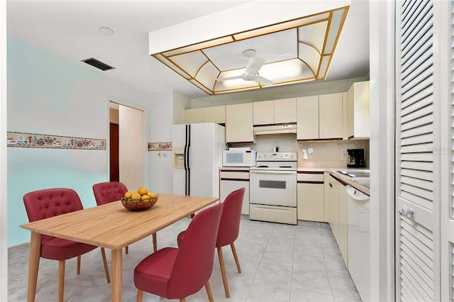 kitchen featuring backsplash, sink, white appliances, and cream cabinetry