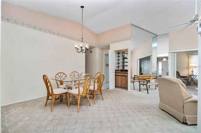 carpeted dining area with ceiling fan with notable chandelier and vaulted ceiling