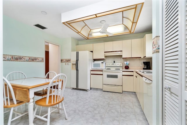 kitchen featuring decorative backsplash, cream cabinets, white appliances, and sink