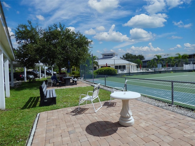 surrounding community featuring tennis court, a patio area, and a yard