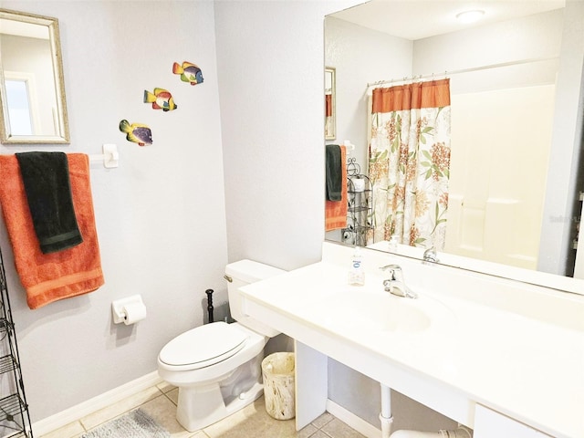 bathroom with tile patterned floors, curtained shower, sink, and toilet