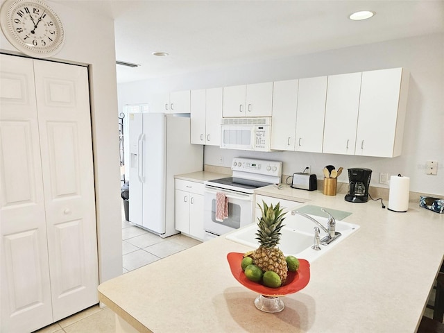 kitchen with white cabinetry, sink, kitchen peninsula, white appliances, and light tile patterned floors