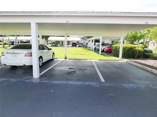 view of parking / parking lot with a yard and a carport