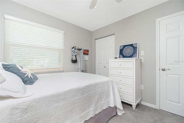 carpeted bedroom featuring ceiling fan and a closet