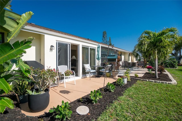 rear view of property featuring a yard and a patio