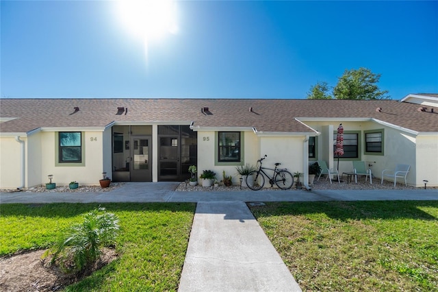 back of property featuring a sunroom and a yard