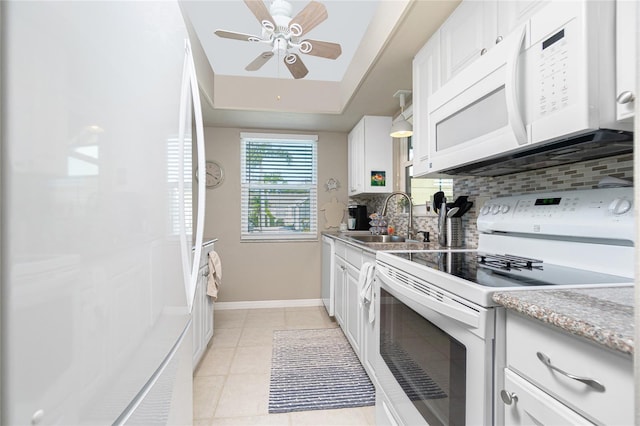 kitchen featuring sink, white cabinets, white appliances, and light tile patterned floors