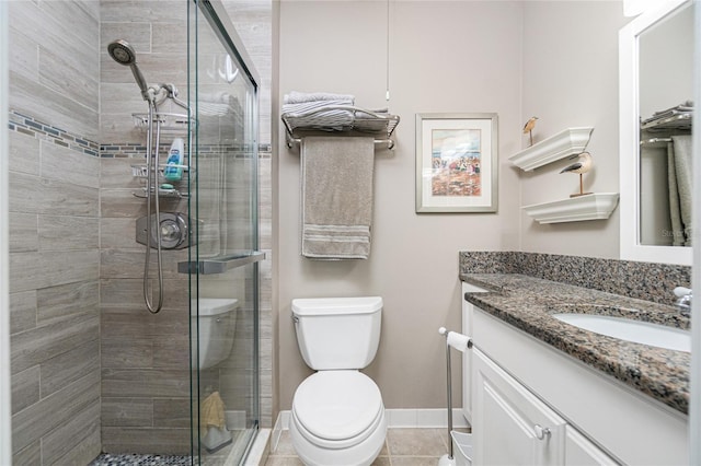 bathroom featuring tile patterned floors, vanity, toilet, and a shower with door