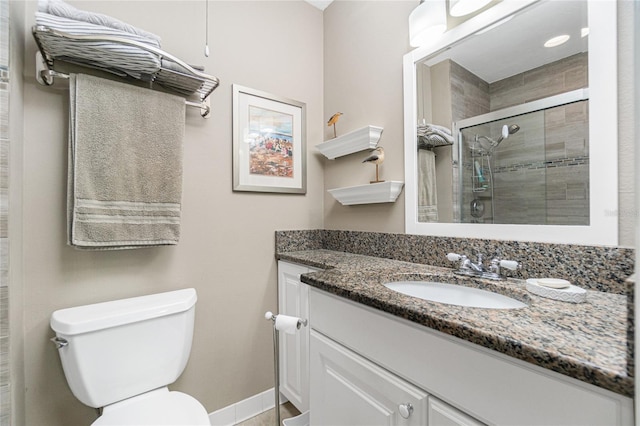 bathroom featuring vanity, toilet, and a shower with shower door