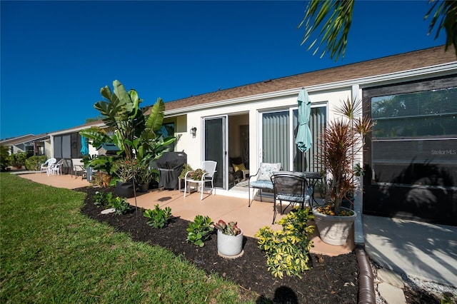 back of house with a lawn and a patio area