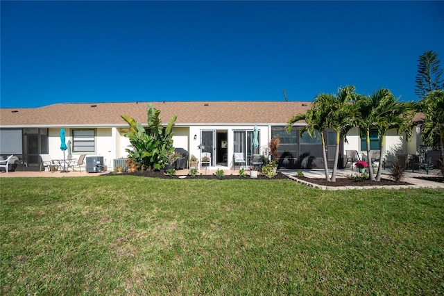 rear view of property featuring a yard, a patio area, and central air condition unit