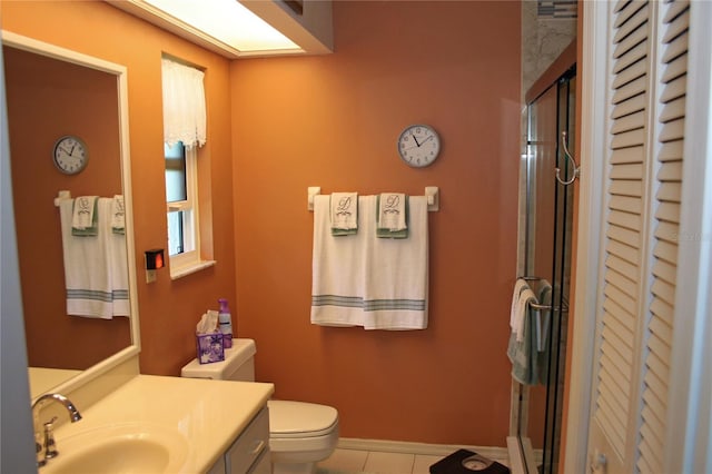 bathroom featuring toilet, a shower with door, vanity, and tile patterned flooring