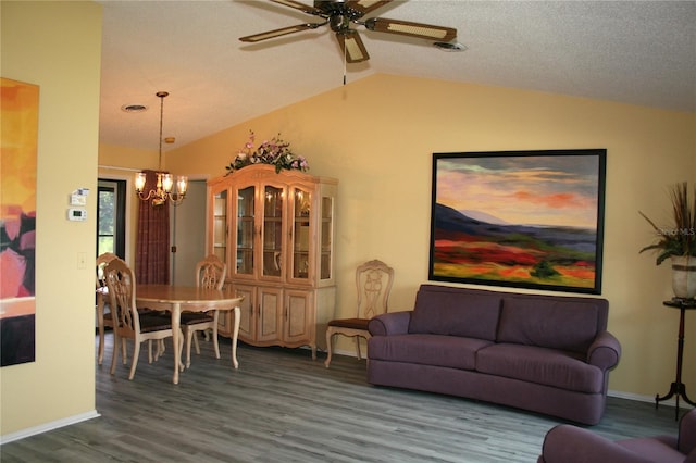 living room with ceiling fan with notable chandelier, lofted ceiling, and hardwood / wood-style flooring