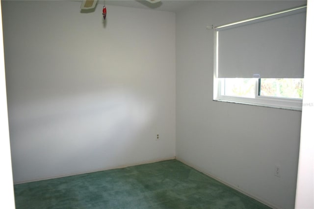 spare room featuring dark carpet