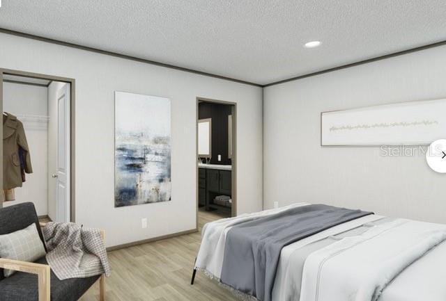 bedroom with ensuite bath, a textured ceiling, and light hardwood / wood-style flooring