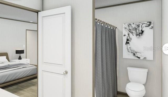 bathroom with toilet and wood-type flooring