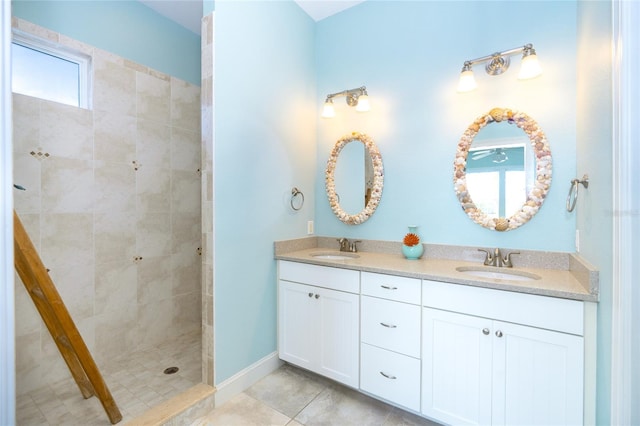 bathroom featuring a tile shower, double vanity, and tile patterned flooring