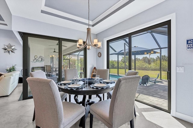 dining space with an inviting chandelier, a raised ceiling, and light tile flooring